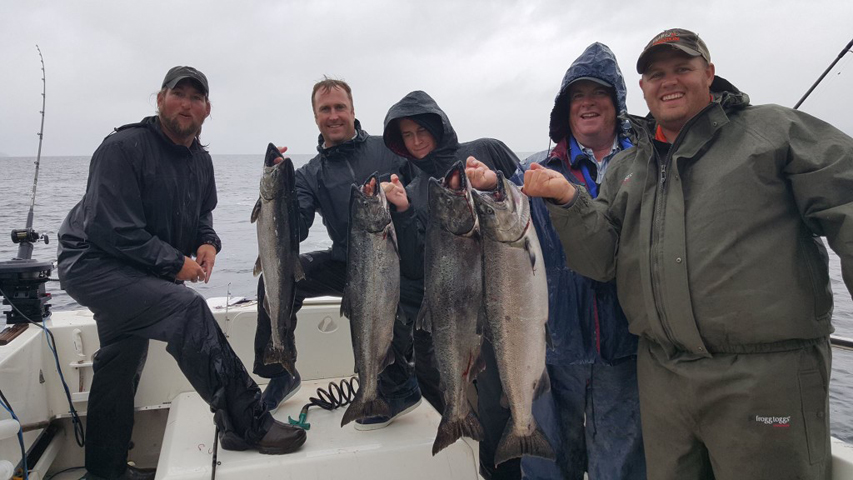 happy group of anglers with alaska salmon